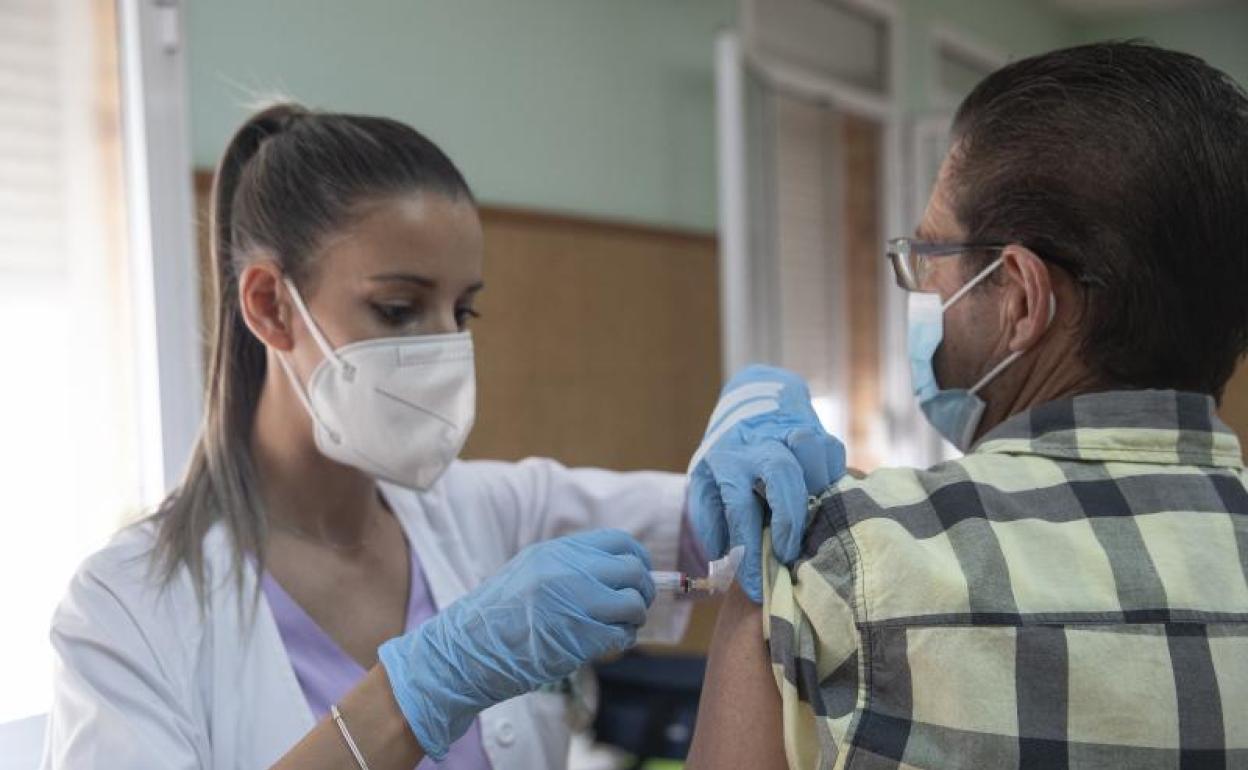 Una enfermera vacuna a un hombre contra la gripe y el Covid en Sevilla. 