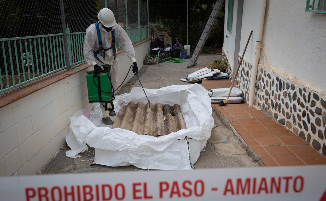 Un trabajador de Contenedores Molina retira amianto del tejado de un particular.