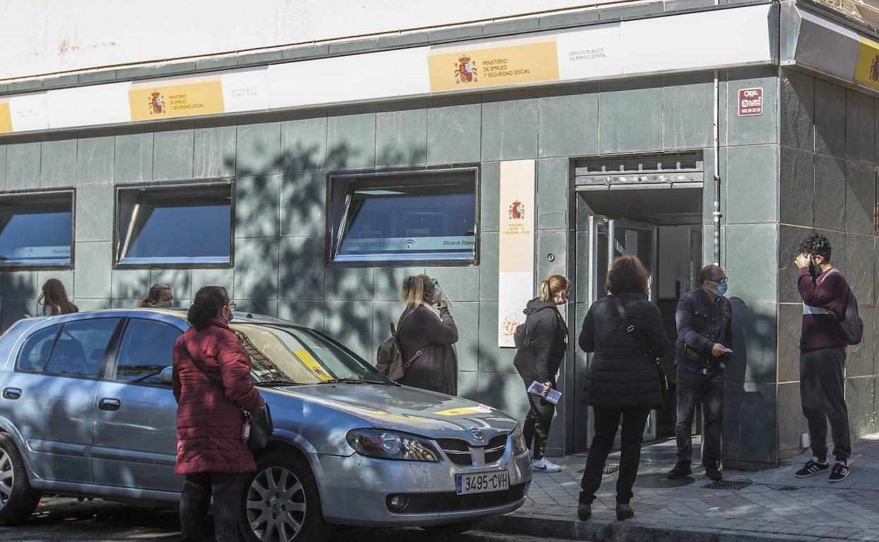 Un grupo de personas espera a las puertas de una oficina de empleo de la capital granadina en una imagen de archivo. 