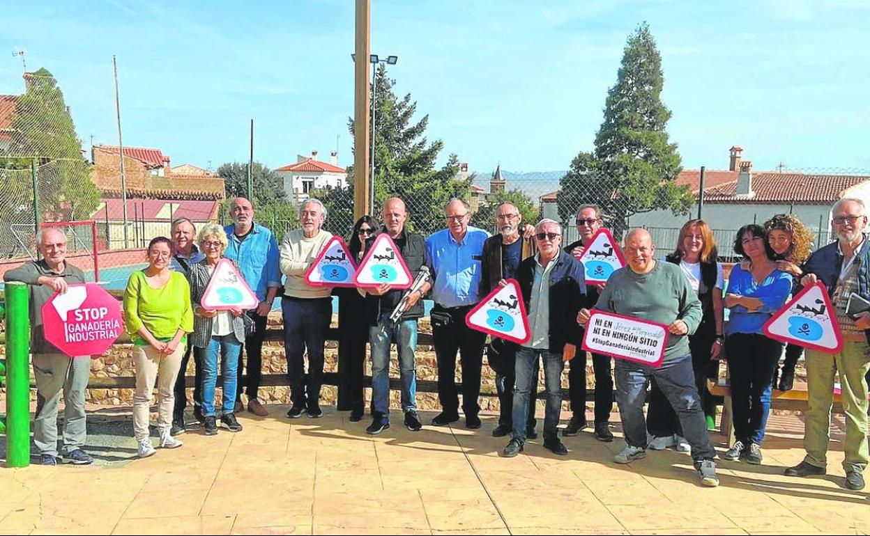 Miembros de la plataforma contra las granjas posan con sus carteles.