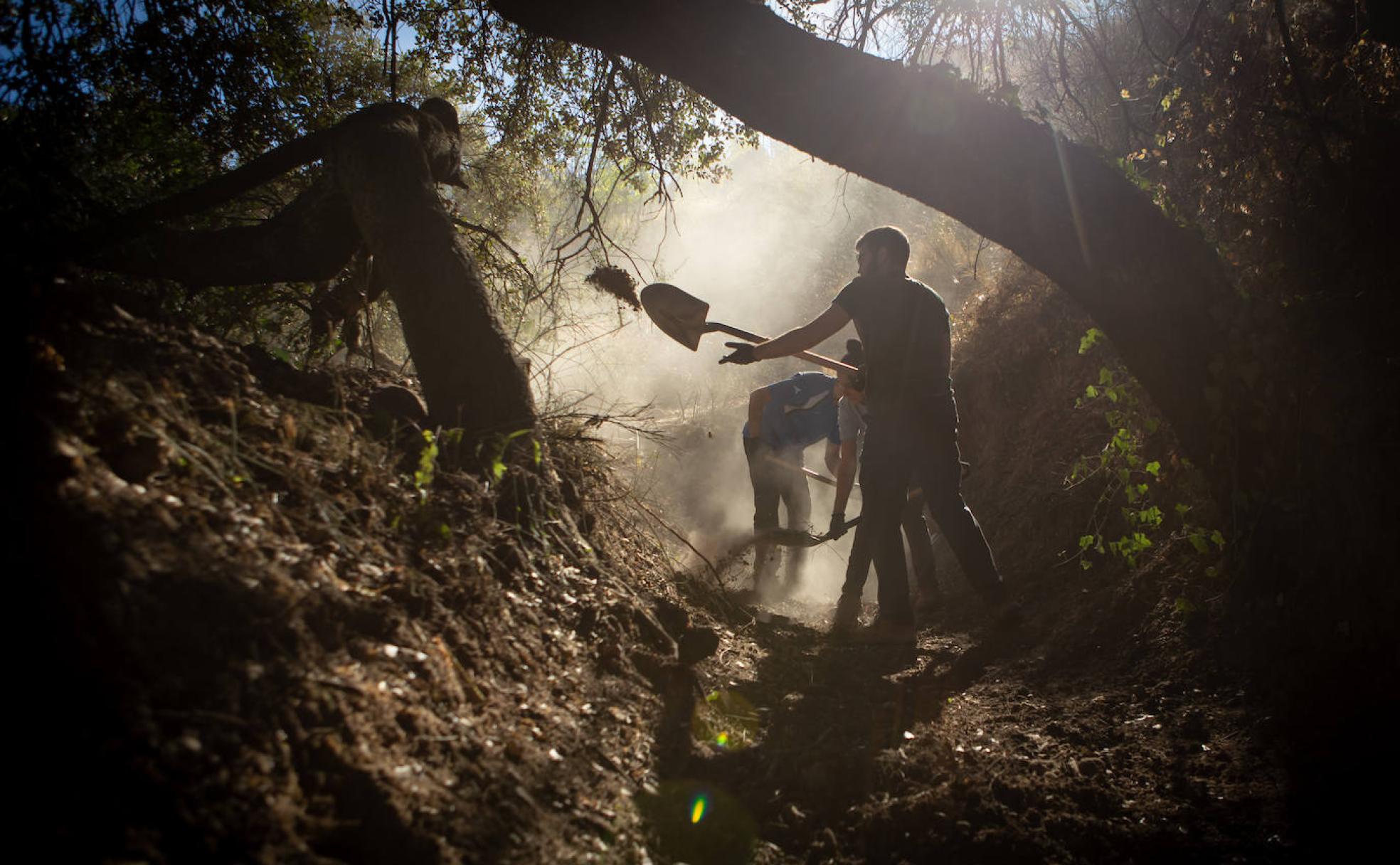 Voluntarios trabajando a primera hora de la mañana en el tramo de acequia que hay junto al Carmen de la Patrona. 