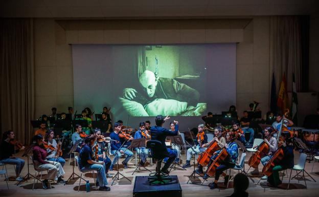 La Orquesta de la Universidad de Granada ensaya la música de Jordi Sabatés ante la atenta mirada de Max Schreck como Nosferatu. 