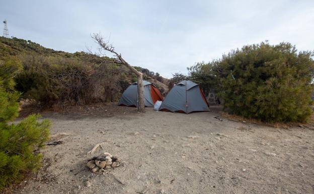 Imagen principal - Solo un paseo por el cerro de San Miguel basta para ver caravanas aparcadas y tiendas en el monte. 