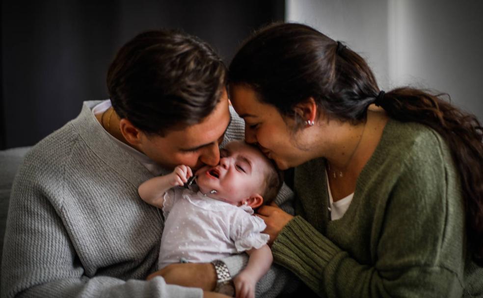 Marina, la bebé de Granada que es uno de los cien casos con síndrome CLIFAHDD, en brazos de sus padres.