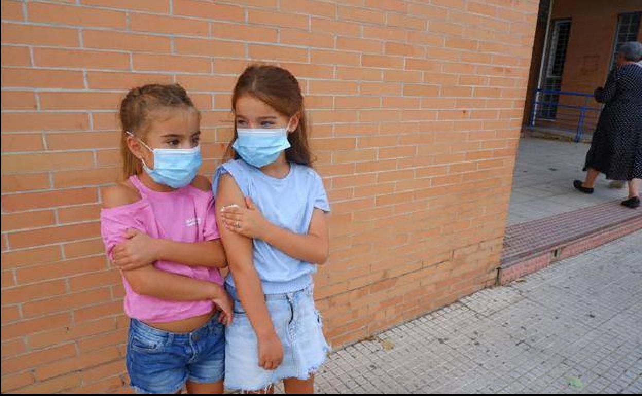 Dos niñas granadinas tras recibir la vacuna de la gripe.