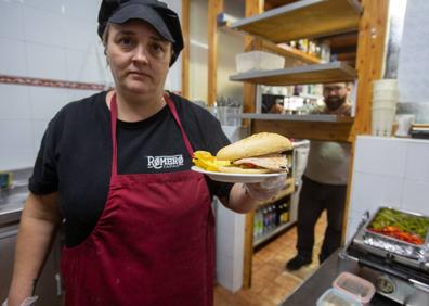 Imagen secundaria 1 - Manuel, Filomena y Moisés, comparten anécdotas y recuerdos en la barra del bar Romero. Tatiana, a los mandos de la cocina. Manuel degusta la tapa que lleva su apellido.