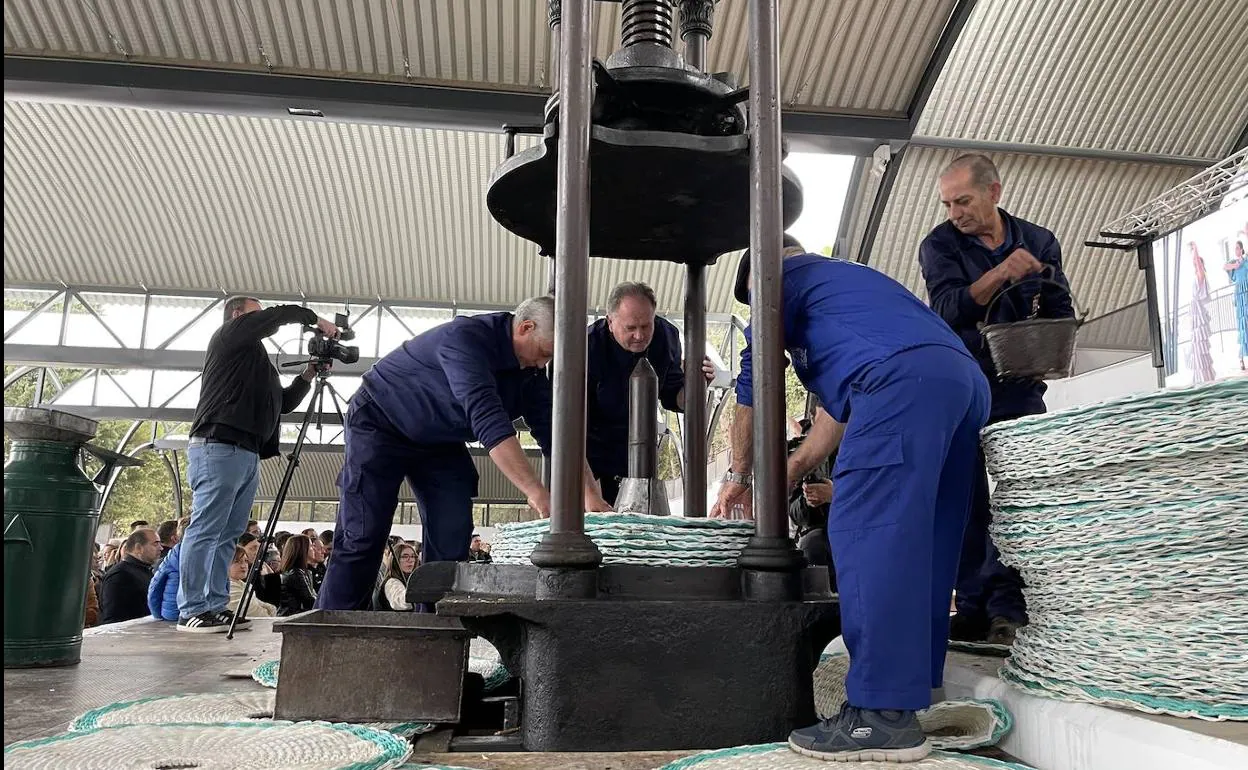 Acto de extracción simbólica del primer aceite del año con una prensa de husillo de tracción manual. 