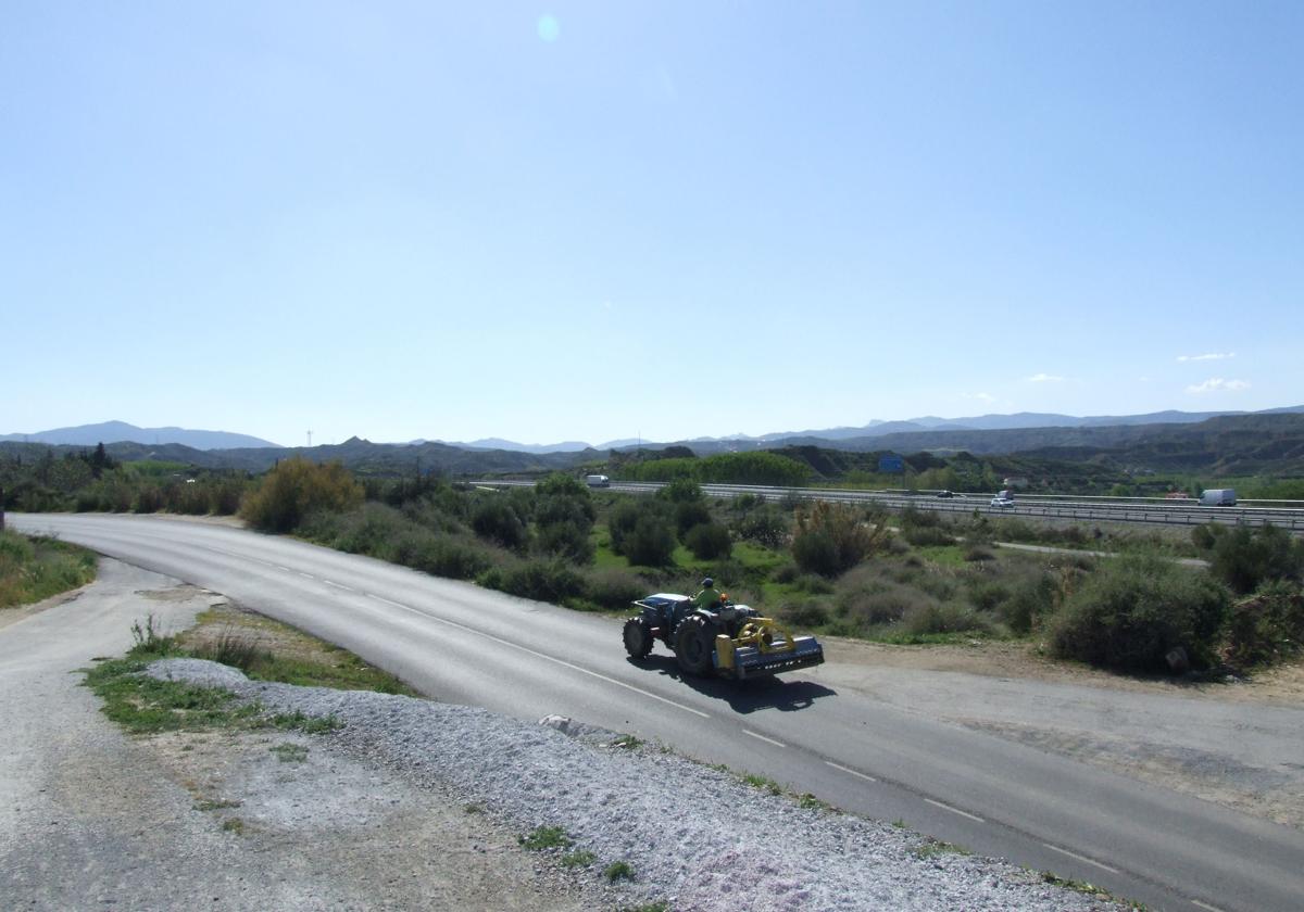 Un tractor circula por una zona de uso industrial en Purullena.