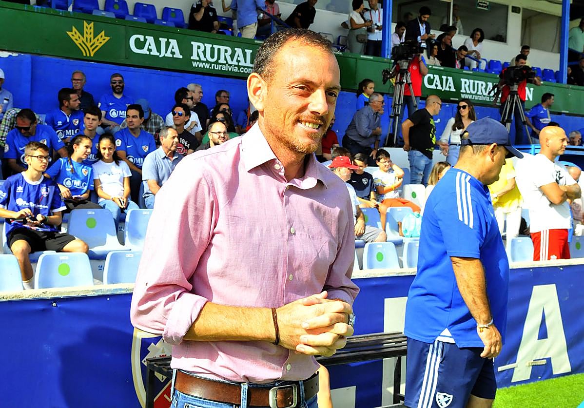Alberto González viendo a sus hombres calentar en un partido en casa. enrique.