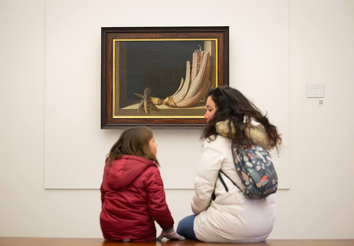 Madre e hija conversan delante del bodegón de Sánchez Cotán.