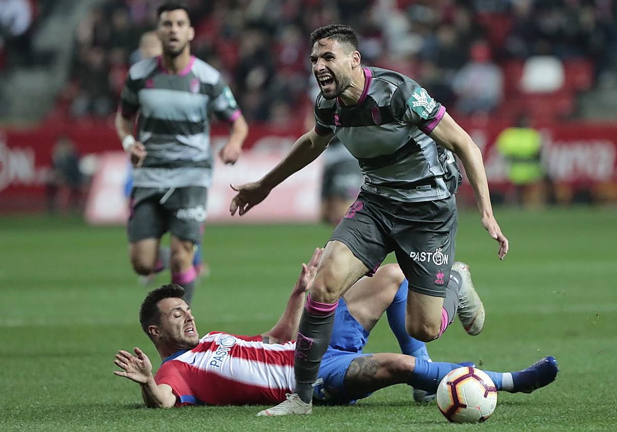 Antonio Puertas recibe una entrada en la última visita del Granada a Gijón, en 2019.