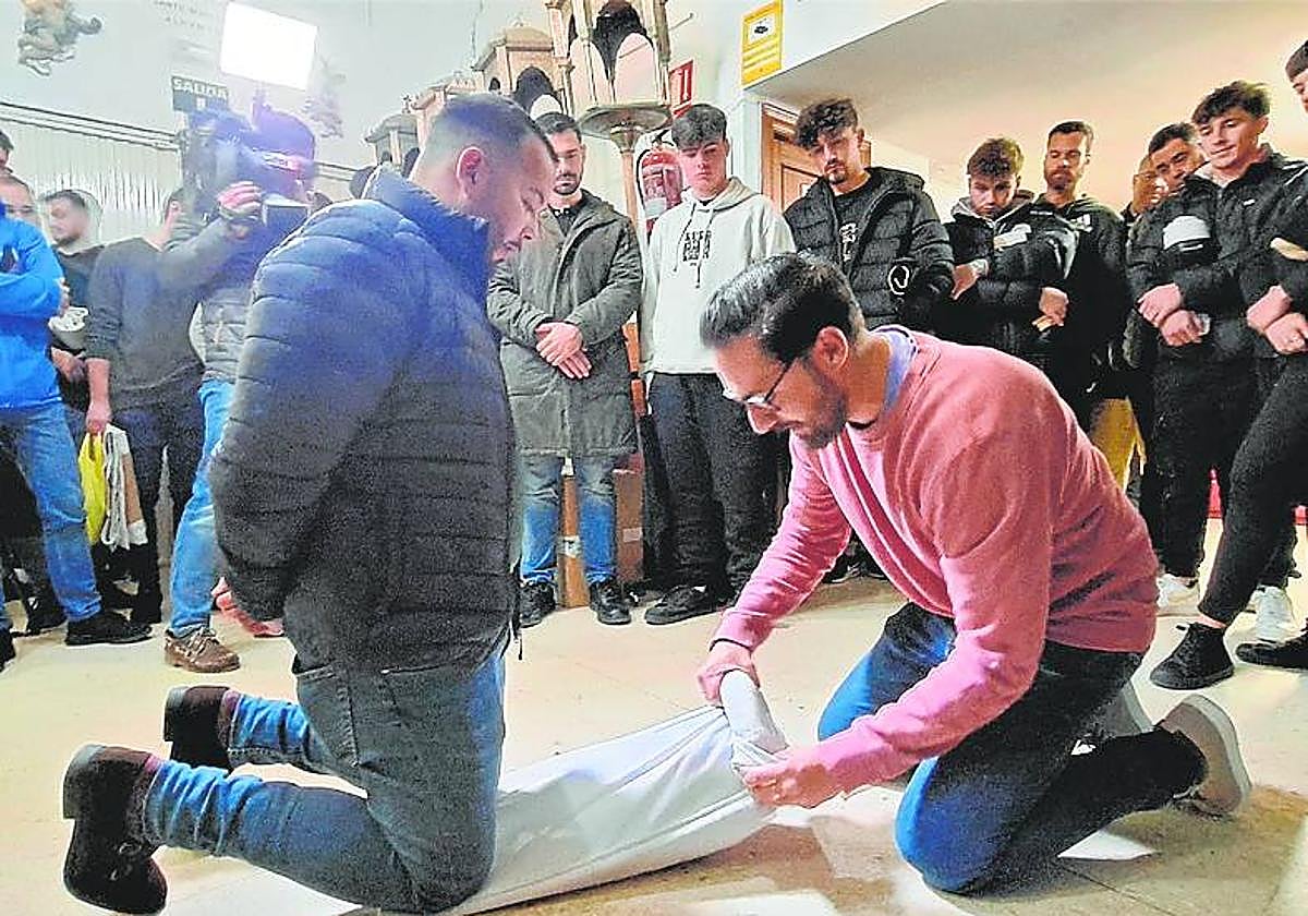 Un veterano muestra cómo enrollar la 'morcilla' en el costal.