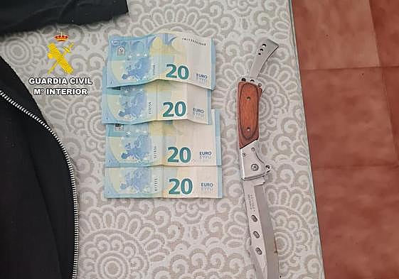 Dinero y una de las armas encontradas en la vivienda del atracador