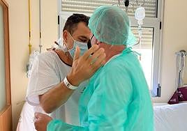 Javier, con la bata blanca, recibe el primer abrazo de su cuñado días después de la operación.