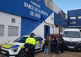 Un agente acompaña a los menores en la entrega de productos al Banco de Alimentos.