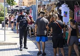 Un agente de la Policía Local recordando la obligatoriedad de usar mascarilla en las calles de Almería.