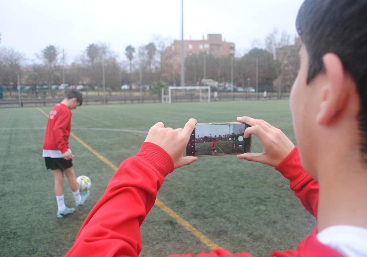 Un jugador de fútbol de La Chana da toques mientras un compañero de equipo lo graba con su teléfono móvil para las redes sociales.