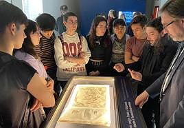 Estudiantes escuchan las explicaciones sobre uno de los documentos expuestos.