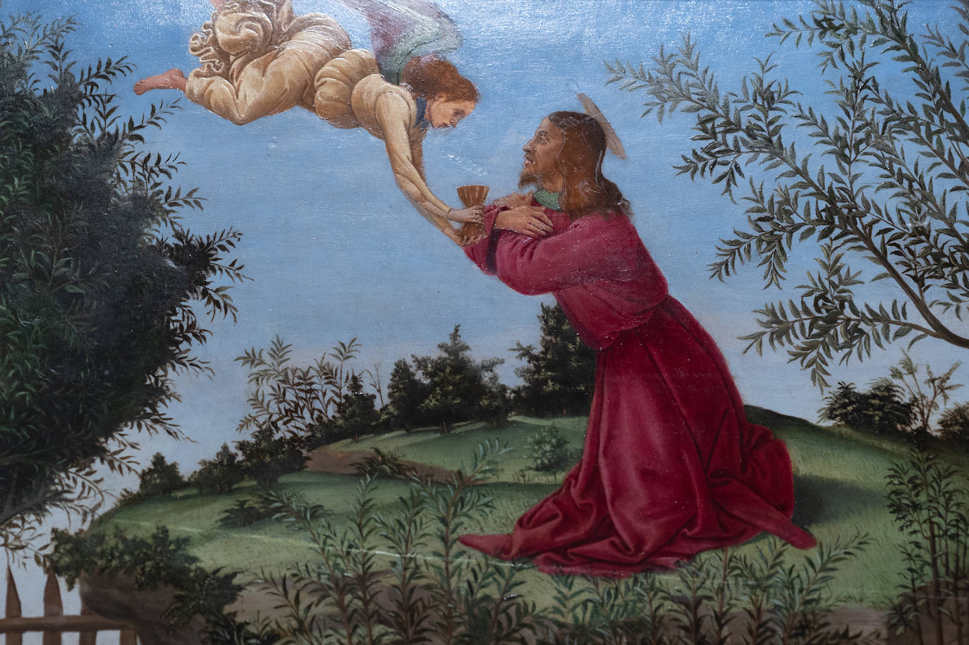 El Señor, vestido con túnica roja, es reconfortado por el ángel en la Oración del Huerto de los Olivos.