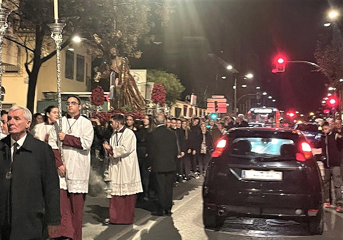 Vía Crucis de la cofradía del Trabajo en la avenida de Dílar junto a los coches
