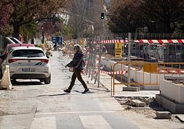 Una vecina cruza la zona de obras en la carretera de Málaga.