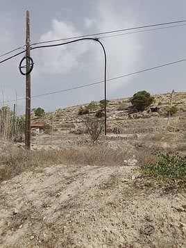 Un poste telefónico con un cable colgando.