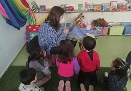 Niños de una guadería prestan atención a la lectura que efectúa su maestra.