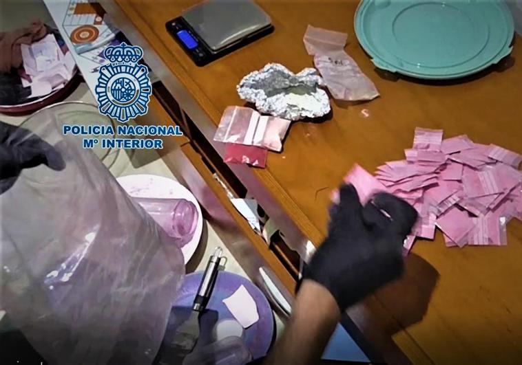 Un policía nacionalinspecciona varias papelinas de 'tusi' incautadas en una operación en marzo.