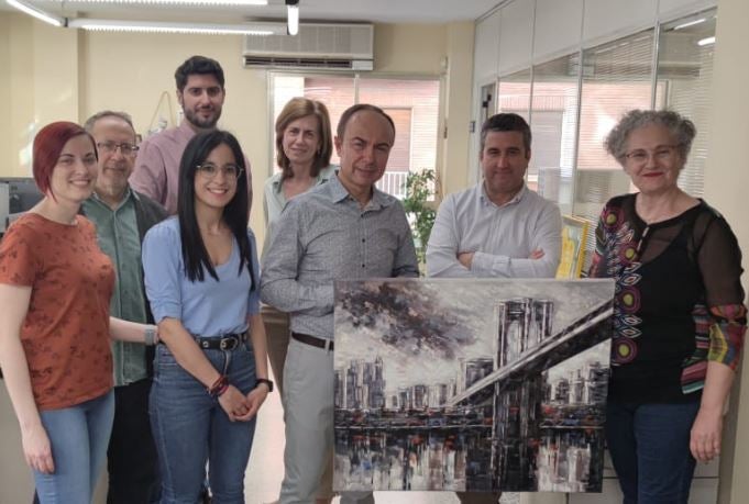 Trabajadores del IDEAL en Jaén con José Domínguez y el cuadro 'El Puente de Brooklyn'.