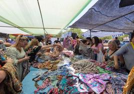 Un grupo de mujeres busca vestidos en un tenderete del mercadillo de Almanjáyar.