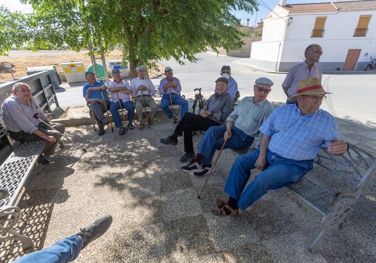 Imagen principal - Los jubilados de Escúzar, a la sombra. Los regentes del bar 'El Morenete' y Bárbara con su gorra.