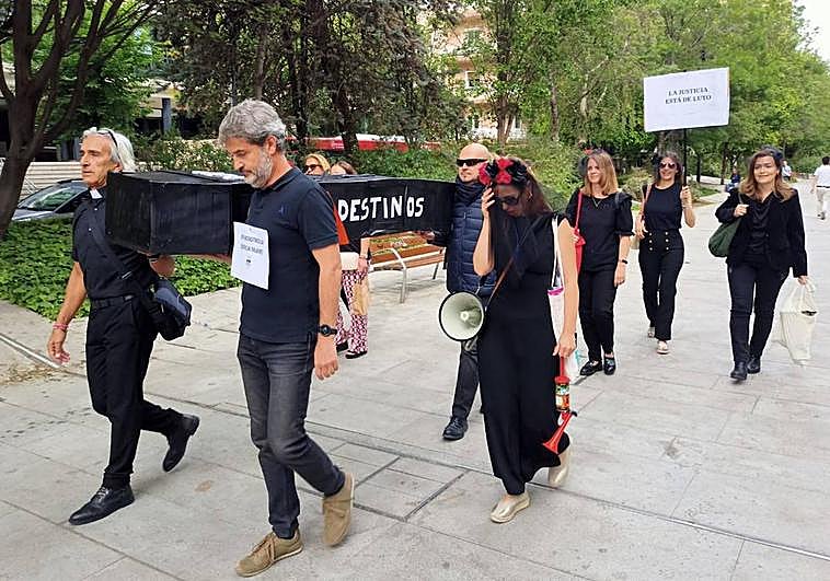 Representantes sindicales llevan a hombros el ataúd simbólico.