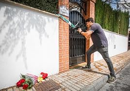 Un cámara, junto a las flores y los peluches depositados junta a la casa en la que ocurrió el crimen