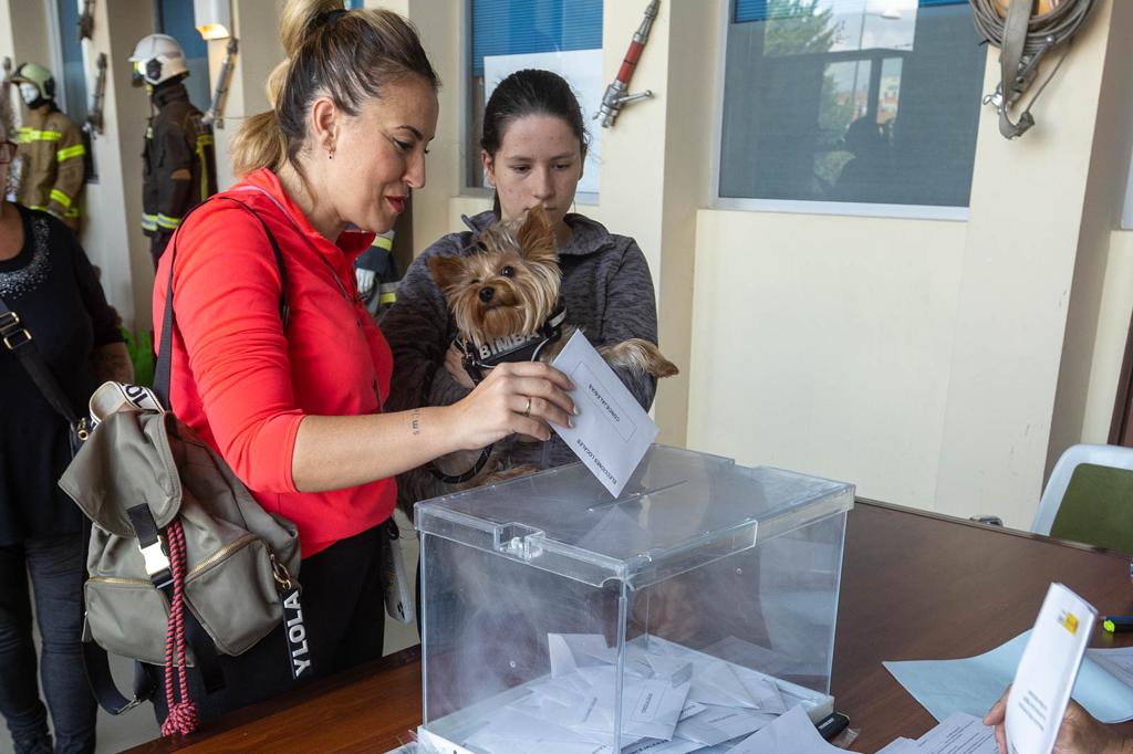 Una granadina deposita su voto ante la mirada de su mascota.