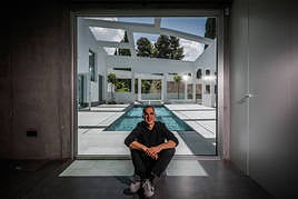 Rubens Cortes en el zaguán de acceso a la casa con el patio como fondo.