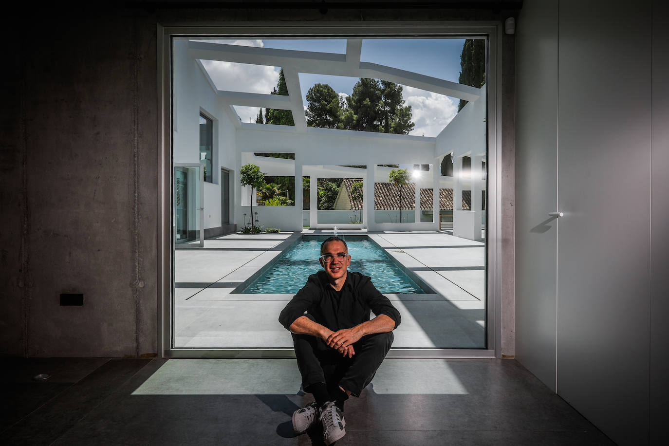 Rubens Cortes en el zaguán de acceso a la casa con el patio como fondo.