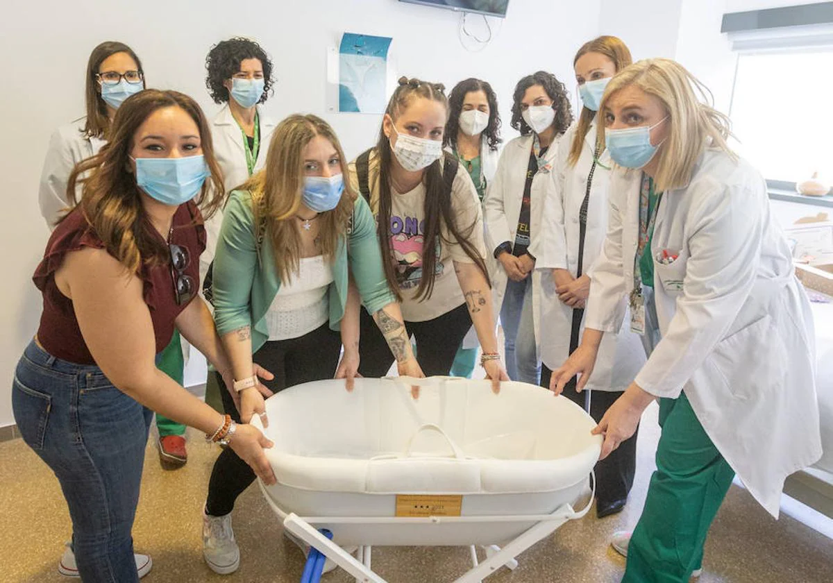 Madres y profesionales sanitarios del Clínico posan con la cuna fría.