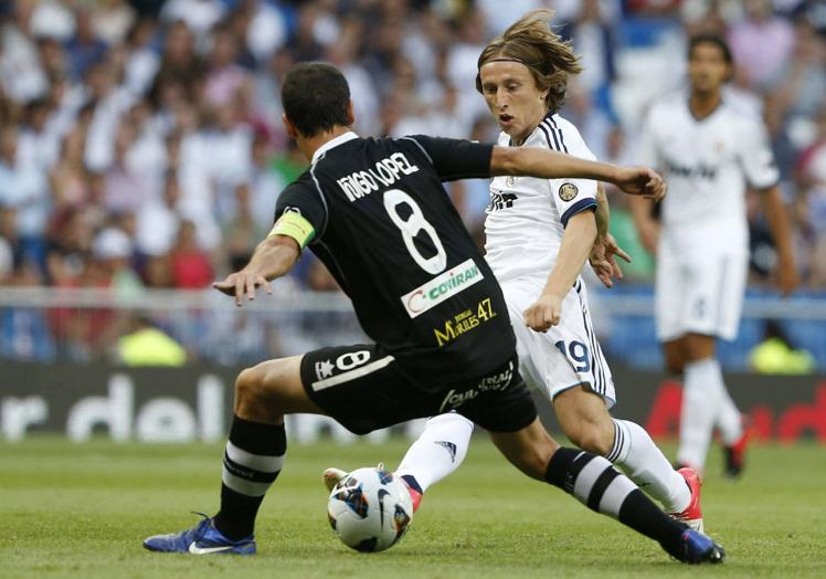 El defensa del Granada CF Iñigo López (i) intenta robarle la pelota al centrocampista croata del Real Madrid, Luka Modric, en 2012.