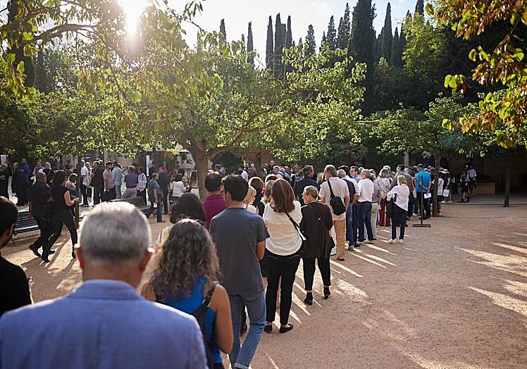 Imagen principal - Colas de entrada y personal del concierto, indicando cómo guardar el móvil en la bolsita. 