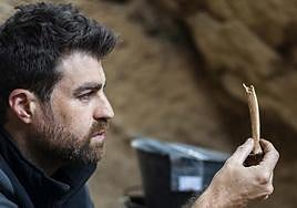 Ignacio Martín Lerma sostiene un hueso en una de sus recientes excavaciones.