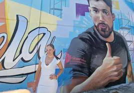 Bárbara Roldán posa delante de un mural que pintó en una de sus gestorías, en recuerdo a un compañero.