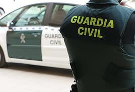 Guardia civil junto al una unidad del cuerpo armado.
