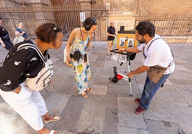 Dos turistas atienden a Antonio.