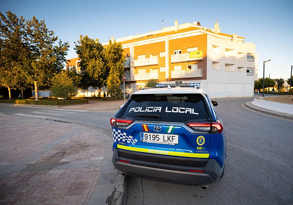 Coche de la Policía Local aparcado enfrente del bloque «okupado».