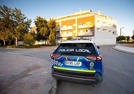 Coche de la Policía Local aparcado enfrente del bloque «okupado».