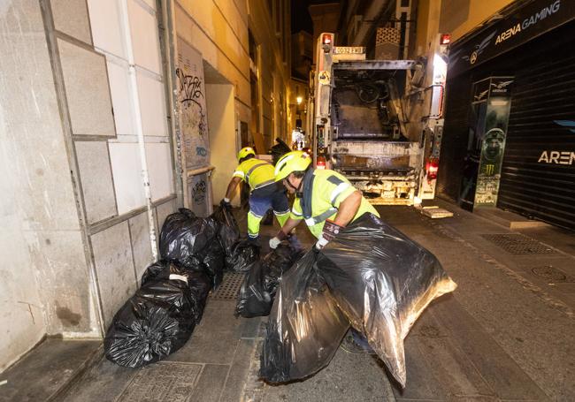 Javier y Luis recogen la basura depositada en las calles.