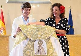 La sonrisa de Jorge Martínez es notoria cuando María del Mar Vázquez le entrega el Capote.