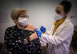 Una profesional sanitaria vacuna a una mujer contra la covid.