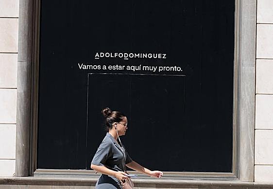 Un cartel en la ventana del edificio de Puerta Real donde abrirá la firma.