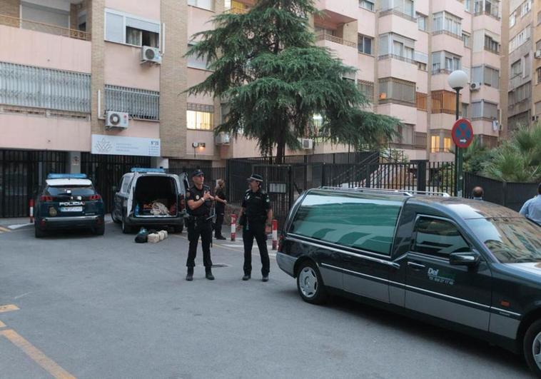 Agentes de la Policía Nacional junto al coche fúnebre en la avenida de Madrid